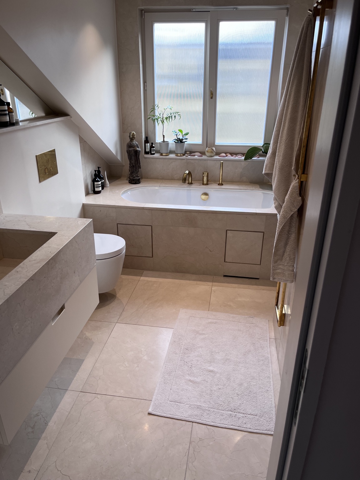 Baño con revestimiento de piedra en tonos cálidos